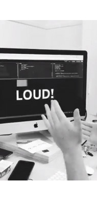 A pair of hands clapping with a computer screen in front showing the word Loud!, the video tweet of this shows the word getting bolder as it gets noisy
